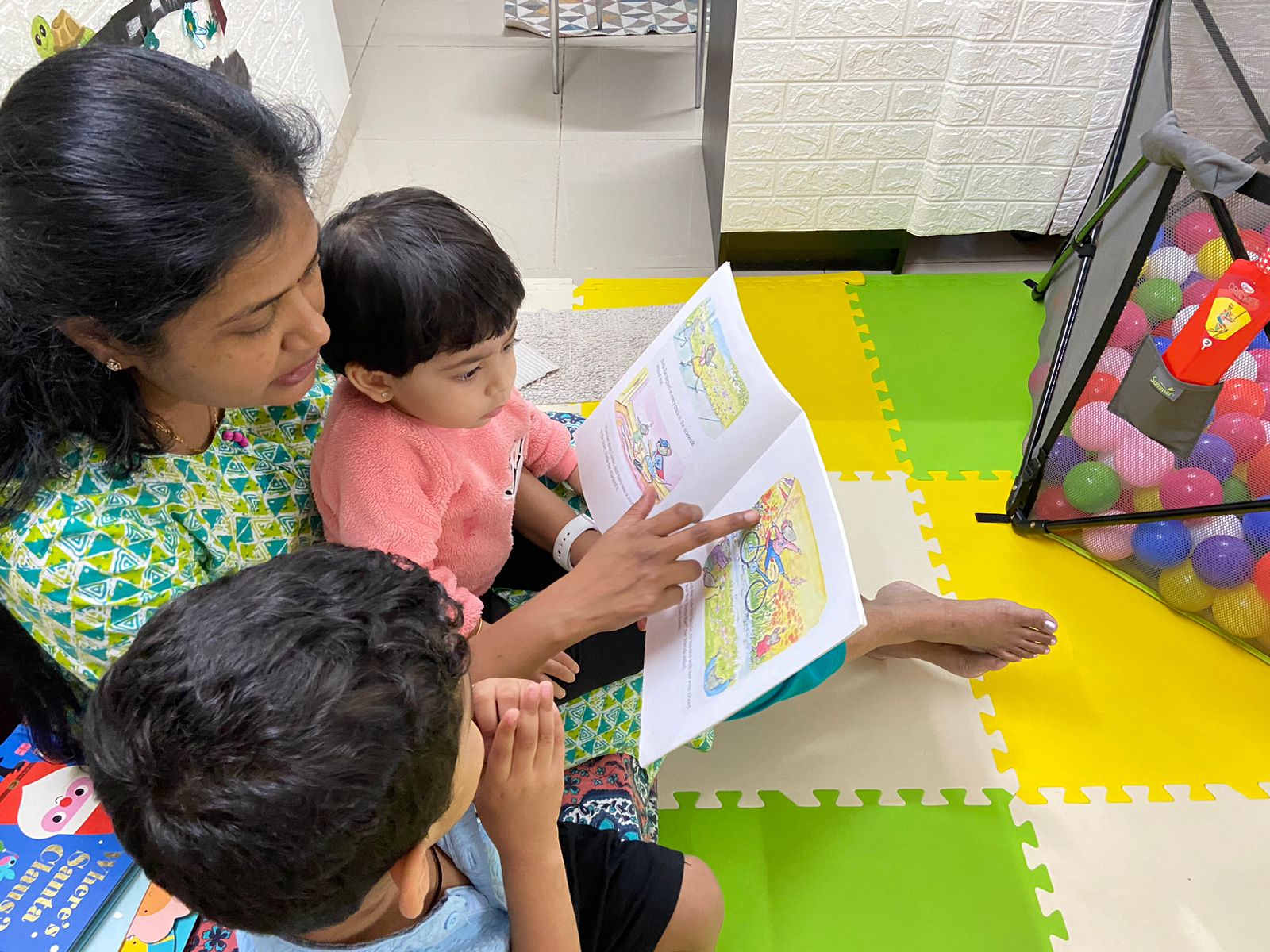 Teacher reading books to preschool kids at Caterpillar Care Preschool @ Brigade Golden Triangle
